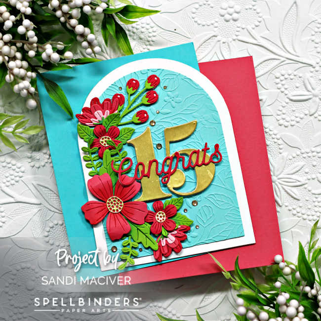 turquoise and white arched shaped card with a cascade of pink flowers and green leaves down the left side and the number 15 in gold in the center with congrats across the center