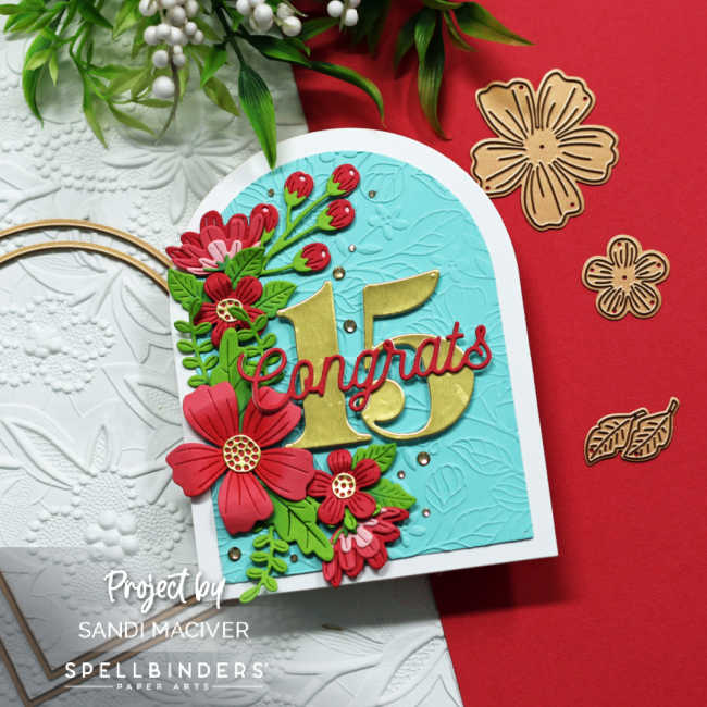 turquoise and white arched shaped card with a cascade of pink flowers and green leaves down the left side and the number 15 in gold in the center with congrats across the center