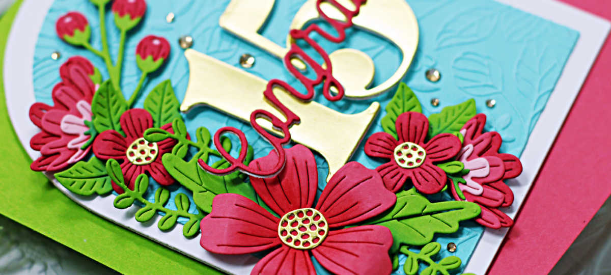 turquoise and white arched shaped card with a cascade of pink flowers and green leaves down the left side and the number 15 in gold in the center with congrats across the center