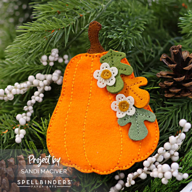 orange felt pumpkin with die cut flowers and leaves cascading down the right side