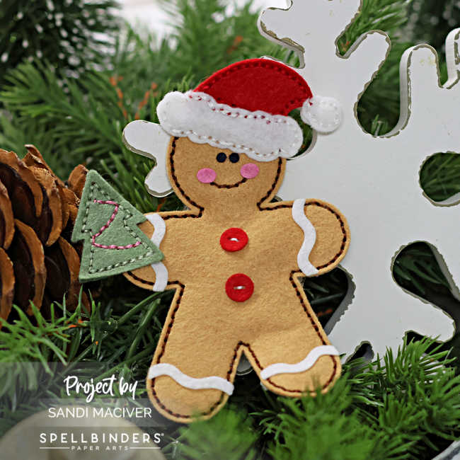 hand stitched felt gingerbread man with a santa hat on holding a felt tree