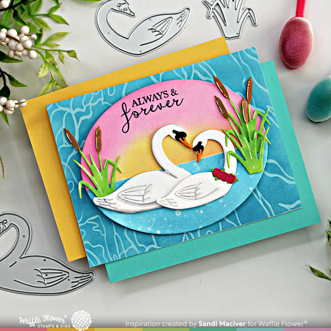 hand made card with a sunset over the water background and two die cut swans surrounded by bull rushes