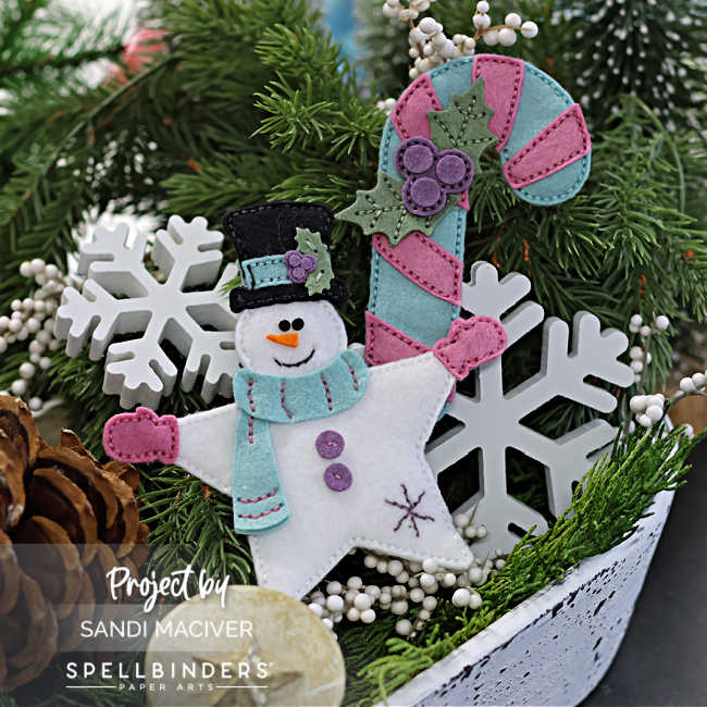 felt snowman and candy cane sewing in teal blue, pink and purple, in a dough bowl filled with holiday greenery