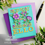 teal colored card with a gold die cut H decorated with purple flowers and green leaves