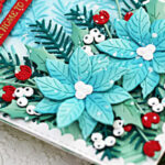blue white and red holiday card with blue poinsettia, green holly and red berries on a embossed background with a white border