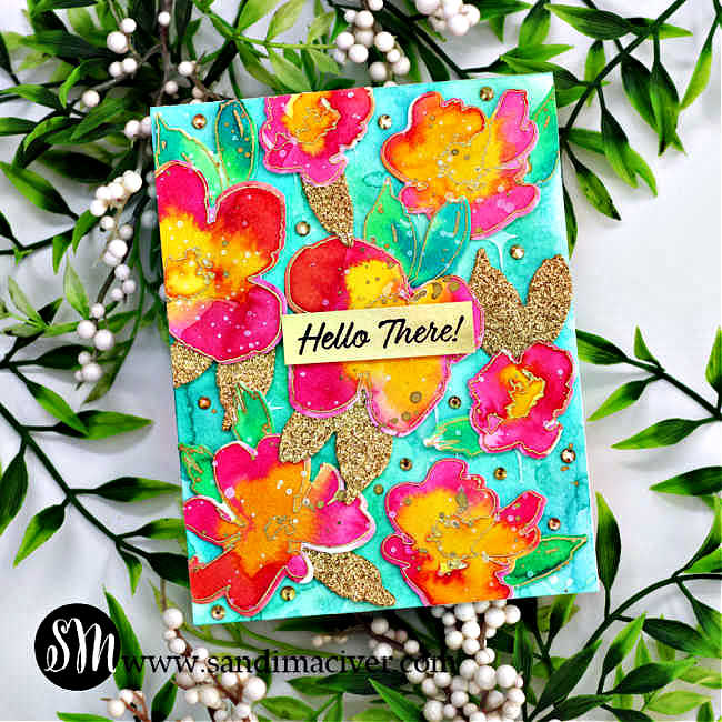 handmade watercolor card with a turquoise background covered with yellow and pink watercolor flowers, green leaves and gold leaves with a gold and black sentiment in the middle