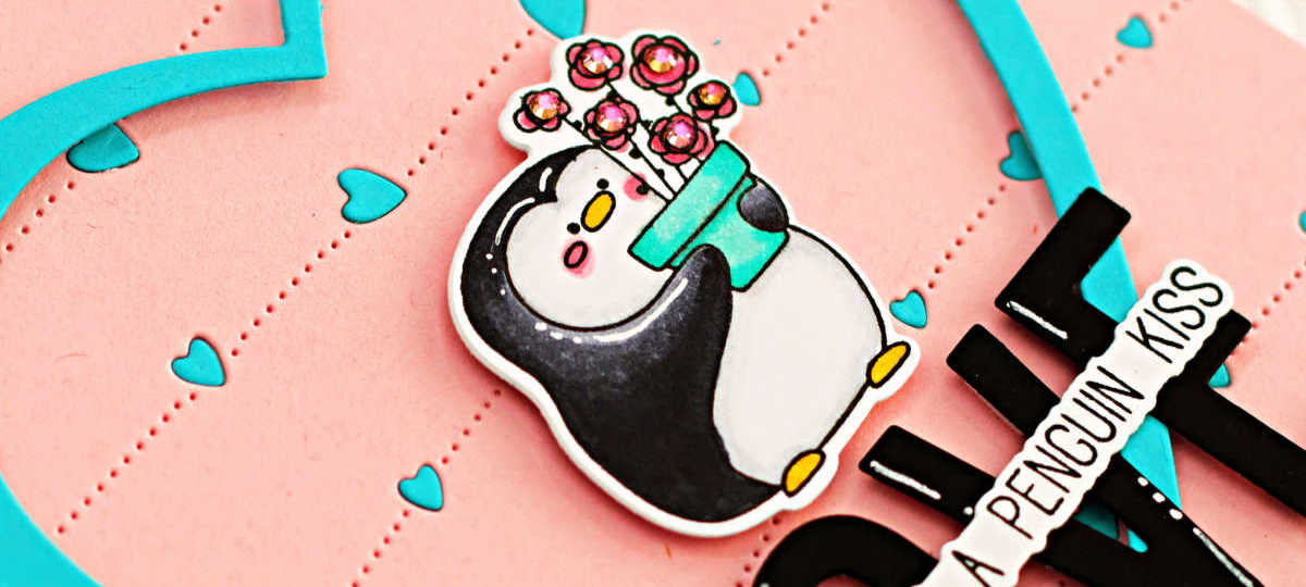 hand made pink card with blue inlaid hearts, a large overlay blue die cut heart with a black and white penguin holding a pot of roses