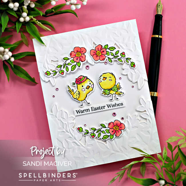 handmade card with a white leaf embossed background with two cartooned chicks in the center and a cascade of flowers around them.