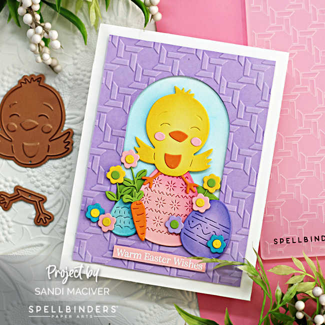 hand made easter card with a purple basket embossed front, and a die cut yellow chick sitting on top of rainbow easter eggs