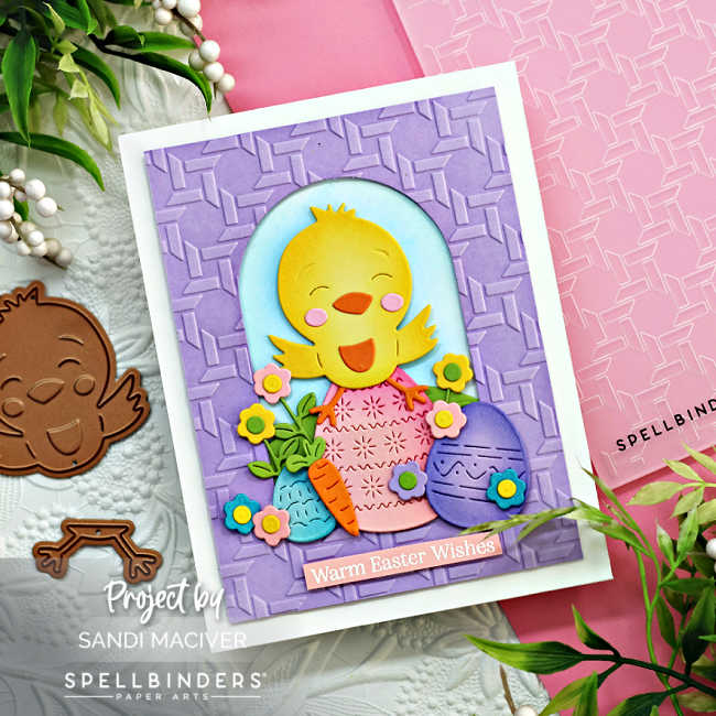 hand made easter card with a purple basket embossed front, and a die cut yellow chick sitting on top of rainbow easter eggs