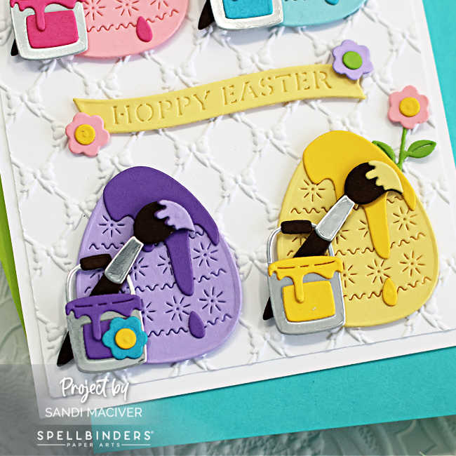 bottom portion of a hand made Easter Card with a purple and a yellow painted easter egg and little silver paint cans beside each