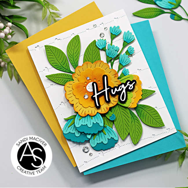 yellow, teal and green floral die cut card with a black and white die cut sentiment and clear rhinestone embellishments