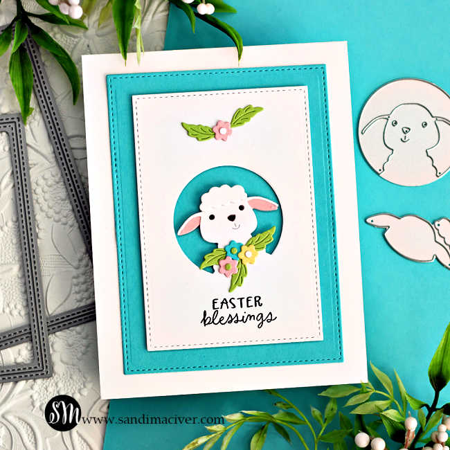 hand made card in teal and white with a cute die cut white lamb surrounded by spring flowers.