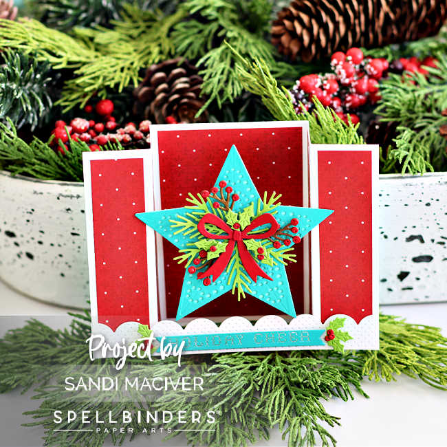 Handmade Christmas bridge card featuring a large dimensional teal star with die-cut pinecones, berries, holly, and a red bow on a red polka dot background. White pierced scalloped borders and a ‘Holiday Cheer’ sentiment complete the festive pop-up design by Sandi MacIver using Spellbinders products