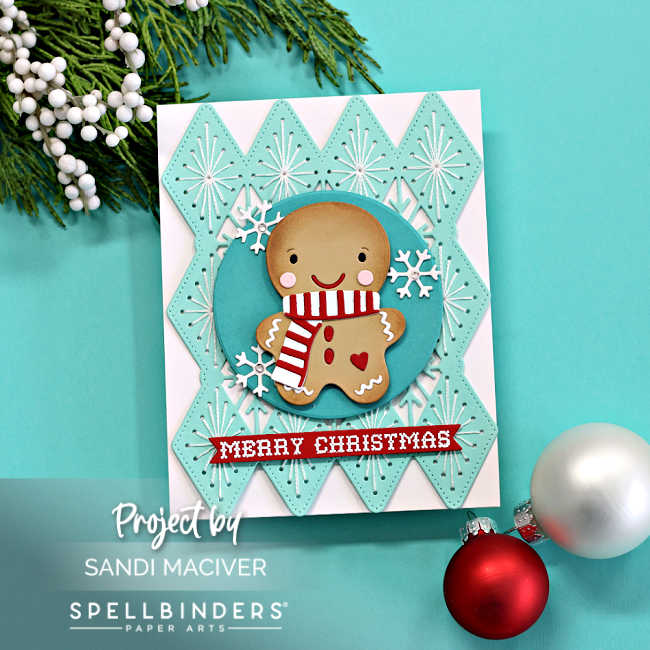 Handmade Christmas card featuring a die-cut gingerbread cookie with rosy cheeks and a red-and-white striped scarf, created using the Spellbinders July Stitched Club of the Month Frosted Stitch and the Caboodle Bonus Die Set of the Month Ginger Sip Die Set. The background showcases a teal stitched snowflake design layered on a white card base. A circular teal panel with white die-cut snowflakes frames the gingerbread figure. A red sentiment strip with a white heat-embossed "Merry Christmas" from the Stay Snuggly Clear Stamp and Die Set of the Month completes the festive design.