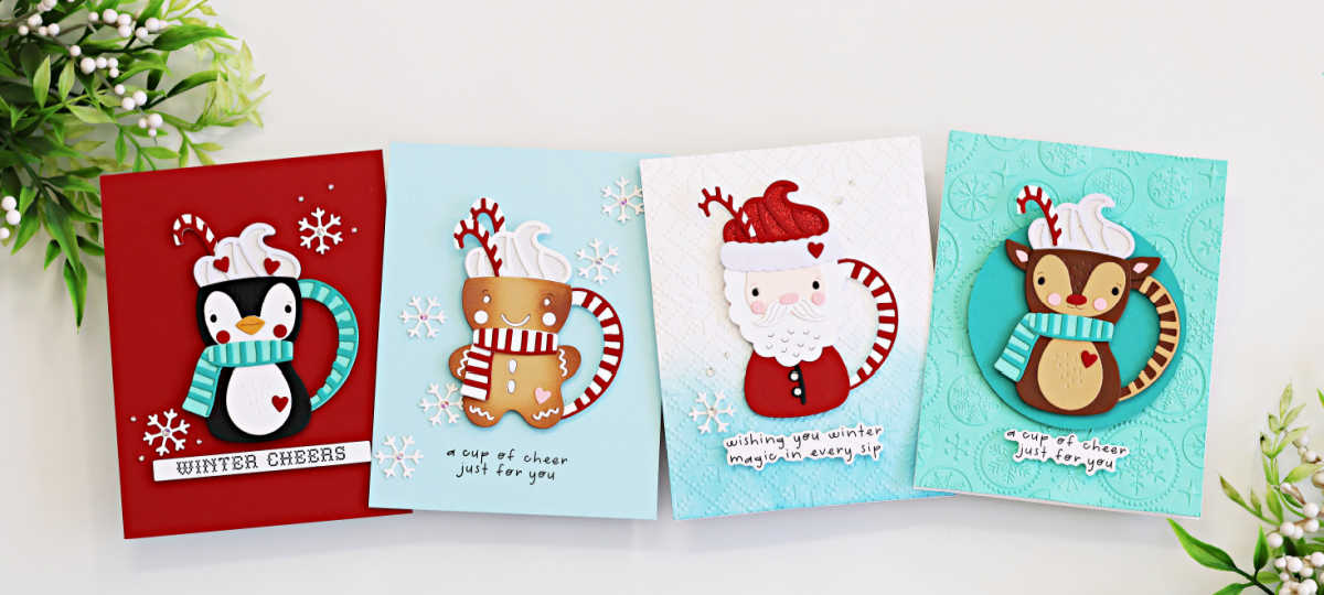 Handmade Christmas cards featuring adorable die-cut mugs shaped like a penguin, gingerbread man, Santa, and reindeer. Each card is embellished with scarves, candy canes, whipped cream, snowflakes, and cheerful holiday sentiments on festive red and blue backgrounds.