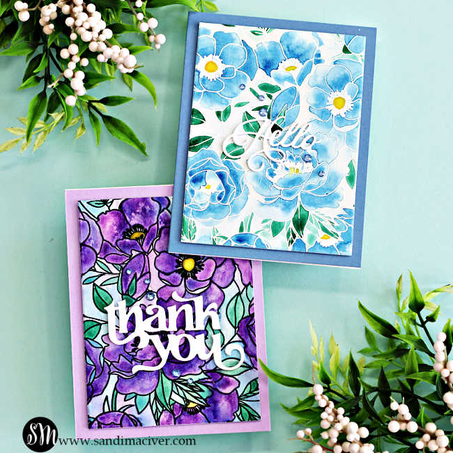 Two handmade cards created with the Simon Says Stamp Delicate Blossoms stamp set, featuring messy watercolor techniques. One card has vibrant purple flowers with green leaves, black heat-embossed outlines, and a bold white 'thank you' sentiment. The other showcases soft blue flowers with yellow centers, green leaves, white heat-embossed outlines, and a delicate white 'hello' sentiment.