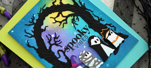 Handmade Halloween card featuring Simon Says Stamp products. The background is an ink-blended midnight sky in blue, green, purple, and yellow tones with white splatter stars. A black die-cut Twisted Tree Arch frames the scene. Inside, the sentiment “spooky vibes” from the Halloween Basics Stamp Set is stamped in black. At the bottom, four cute die-cut ghosts from the Costume Ghost Parade Die Set are dressed in Halloween outfits—a witch with a pumpkin bucket, a mummy, a vampire, and a pirate.