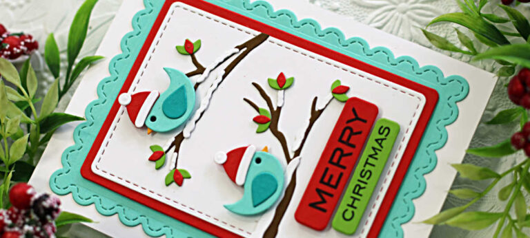 Handmade Christmas card featuring two teal die-cut birds from the Spellbinders Lisa Horton "Little Birdies" Die Set, perched on snow-covered branches with red and green leaves. The birds wear red Santa hats, and the card is framed with layered stitched and scalloped rectangles in white, red, and aqua. A bold sentiment reading “MERRY CHRISTMAS” is stacked vertically in red and green on the right side of the card.