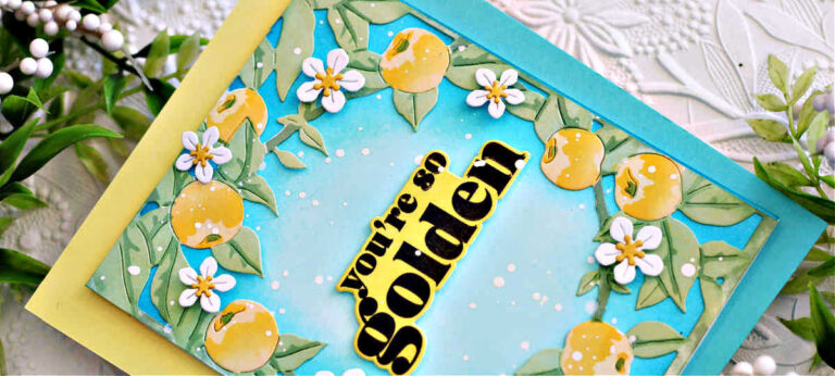 Handmade card created with the Hero Arts You're Golden stamp, die and stencil combo. The card features a turquoise ink-blended background with whit epaint splatters, surrounded by stenciled green leaves, golden yellow applies and white blossoms. The bold sentiment "you're so golden" is stamped in black on an ink-blended yellow layer, creating a fresh, vibrant, summer-inspired design.
