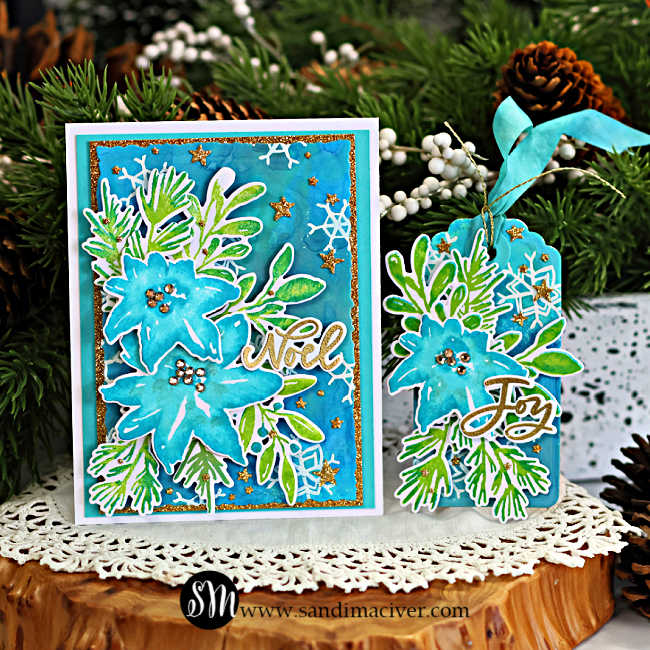 Christmas Card and tag created with the NEW Simon Says Stamp and Tim Holtz Collaboration Festive Watercolor set. The background features a rich blend of Distress Oxide Sprays inEverygreenBough, Tumbled Glass, Mermaid Lagoon, Salvagged Patina, and Broken China. layered on top are bold watercolor-stype poinsettias in Surf, Ocean and Seafom Pawsitively Saturated Inks, with leaves in Pearfection and Ocean. The design is accented with glimmering gold stars and white heat embossed snowflakes, with a die-cut NOEL sentiment heat embossed in gold.
