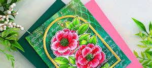 Handmade card created with the Simon Says Stamp and Alex Syberia Designs Beautiful Soul stamp set. The card features two large, copic-colored pink and red flowers with bright green leaves, framed by a gold arch. The background is a layered blend of deep green tones made with Lindy’s Magicals, stenciling, and white heat-embossed text, giving it an elegant yet grungy effect. Gold gem embellishments add a finishing touch.