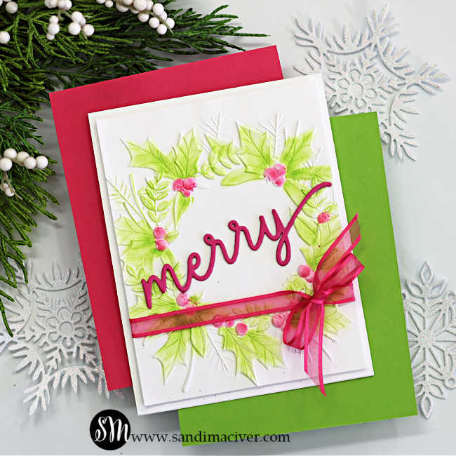 Handmade Christmas card featuring the Simon Says Stamp Festive Wreath Embossing Folder, ink-blended with soft green and pink hues to highlight the raised holly leaves and berries. The card is finished with a bold pink “merry” die-cut sentiment from the Holiday Duo Die Set and accented with a sheer pink ribbon bow tied around the panel. Layered on red and green cardstock for a festive, elegant presentation.