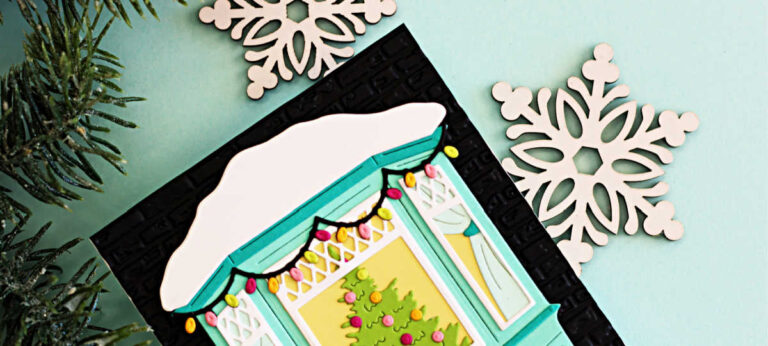 Handmade Christmas card created with the Spellbinders October Large Die of the Month – Window Wonderland. The design features a teal bay window with white snow on the roof, colorful holiday lights, and a decorated Christmas tree visible inside. A child in winter clothing pulls a sled stacked with bright gift packages across a snowy ground in front of a black embossed brick wall background.