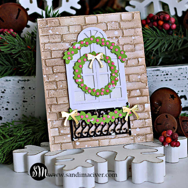 Handmade die-cut Christmas card with a white arched window, green wreath, and garland with gold bows against a brick embossed background, created using Simon Says Stamp dies