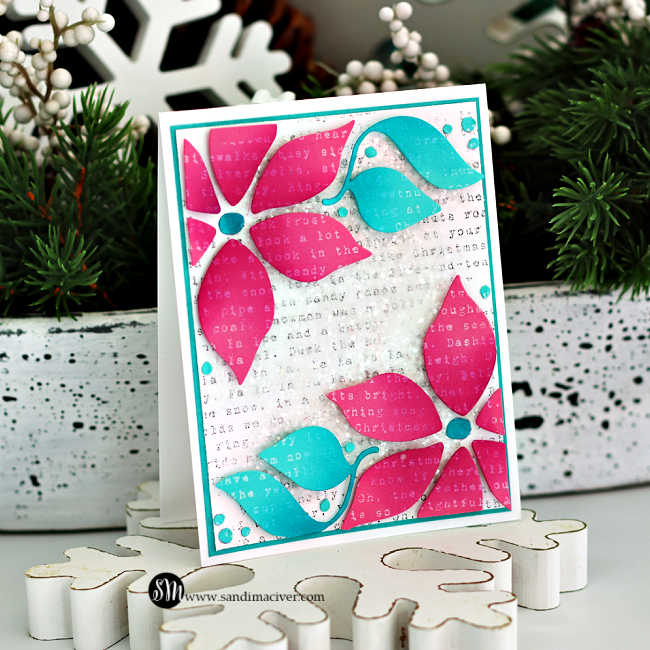 Handmade Christmas card featuring a bold poinsettia design die-cut in bright pink and aqua cardstock. The background is stamped with a light gray text print and topped with Distress Grit Paste and chunky glitter for a snowy mixed-media texture. Aqua enamel dots are added as accents, and the card is layered onto a white and teal cardstock frame for a modern holiday look.