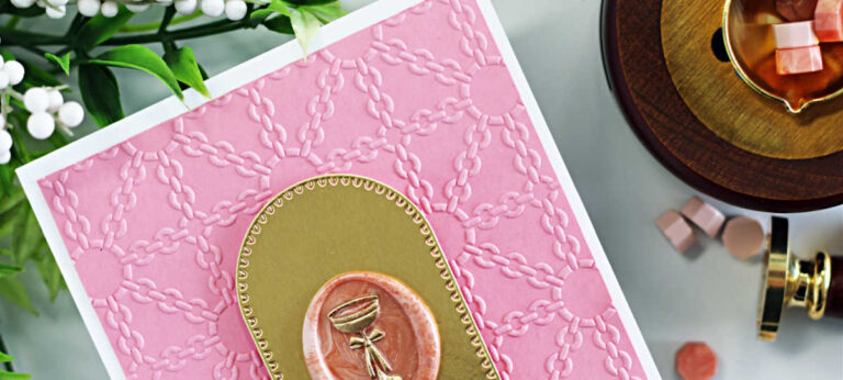 A handmade pink card created with the Spellbinders November Clubs featuring a luxe chain-style background embossed with the Luxe Lattice Embossing Folder. The focal point is a gold arched frame with a marbled coral wax seal stamped with a gold champagne glass design from the Cin Cin Wax Seal of the Month. Below the wax seal is a black and gold sentiment from the BetterPress Club “Paws in the City” set that reads: “Life’s more fun with a little flair.” The card is displayed flat lay style with wax beads, a wax seal tool, and greenery styled around it.