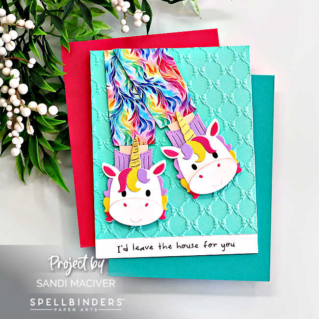 Handmade unicorn slipper card created with the Spellbinders Cozy Toes Friends Die Set and embossed using the Petite Bows 3D Embossing Folder. The card features colorful rainbow pajama pants tucked into whimsical unicorn slippers layered over an aqua embossed background with a playful sentiment strip that reads “I’d leave the house for you.” Designed by Sandi MacIver for Spellbinders Paper Arts.