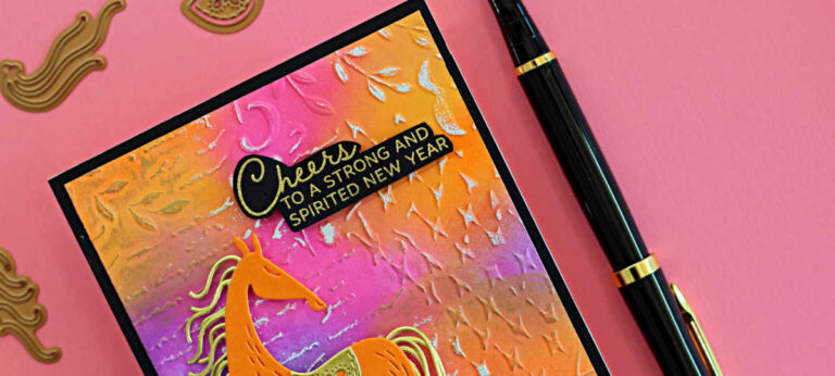 Handmade Good Fortune Horse card with an ink-blended background in pink, orange, and purple distress oxide inks, embossed with the Distress Mix 3D embossing folder and highlighted with gold and white paint. The horse is die-cut from carrot-orange cardstock with gold mirror mane, tail, and saddle. Card displayed on a pink surface with coordinating dies and a black fountain pen beside it.