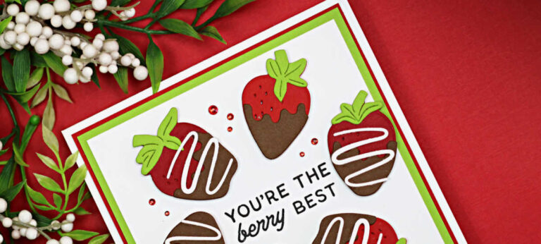 Handmade 5-inch square Valentine card featuring die-cut chocolate-covered strawberries arranged in a circle around the sentiment “You’re the berry best.” The strawberries are layered in red, brown, and green cardstock on a white panel with red and green mat layers, set against a red background.