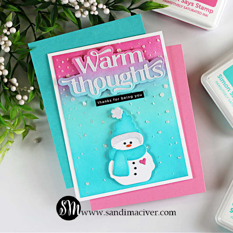 Handmade winter card featuring a bundled snowman die cut wearing a teal hat and scarf on a pink, purple, and teal ink-blended background. The card includes a layered “Warm Thoughts” sentiment at the top, a small “thanks for being you” label, and glitzy falling snow accents scattered across the background.