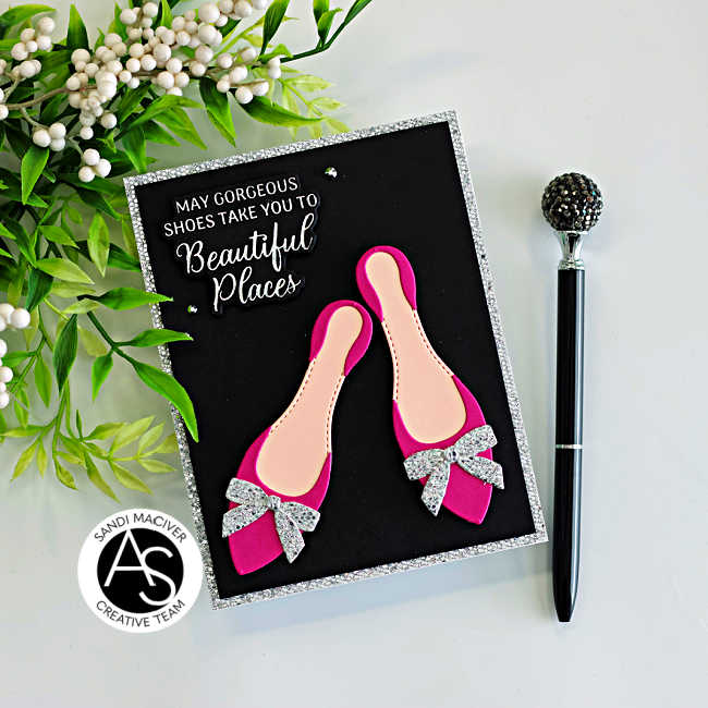 Handmade card featuring bright fuchsia high-heel shoes created with the Alex Syberia Designs Chic Shoes Die Set, each finished with silver glitter bows. The shoes are layered on a black card front with a silver glitter frame, and a white BetterPress sentiment from the Shoes Sentiments BetterPress Plates reads “May gorgeous shoes take you to beautiful places.” Small crystal gems add sparkle to this elegant fashion-themed card.