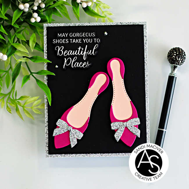 Handmade card featuring bright fuchsia high-heel shoes created with the Alex Syberia Designs Chic Shoes Die Set, each finished with silver glitter bows. The shoes are layered on a black card front with a silver glitter frame, and a white BetterPress sentiment from the Shoes Sentiments BetterPress Plates reads “May gorgeous shoes take you to beautiful places.” Small crystal gems add sparkle to this elegant fashion-themed card.