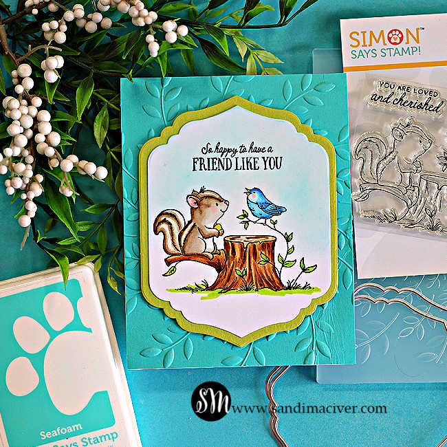 Handmade “Friend Like You” card featuring a Copic-colored squirrel and blue bird on a tree stump, layered on a teal embossed leaf background with a decorative die cut frame. The workspace includes the Simon Says Stamp Friend Like You stamp set and crafting supplies.