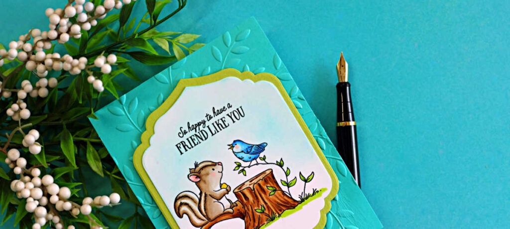 Handmade card featuring a Copic colored squirrel and blue bird sitting on a tree stump with the sentiment “So happy to have a friend like you,” layered on a teal embossed leaf background using an embossing folder and framed with a decorative die cut.