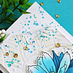 Mixed media slimline card featuring Altenew Sulfur Cosmos with stenciling, white relief paste texture, and blue ink splatter on a white card front