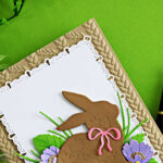 Die cut Easter bunny card featuring Simon Says Stamp Embellished Bunny on a white Ribbon Loop Frames panel with layered flowers and a kraft embossed background
