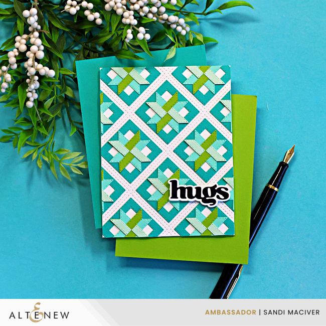 Handmade die cut quilt card featuring a teal and green geometric pattern created with Altenew Patchwork Pathways dies, layered on a teal card base with a bold “hugs” sentiment from the Versatile Greetings die set.