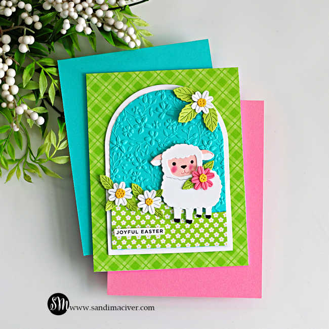 Handmade Easter lamb card created with the Simon Says Stamp Sweet Sheep die and A2 Arches dies, featuring a white sheep holding a flower on an embossed turquoise arch background with daisies and green patterned paper.