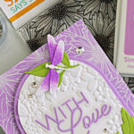 Blooming Wreath embossing folder card idea featuring white heat embossed background, arched design, and layered purple dragonflies from the Dragonfly Duo by Simon Says Stamp