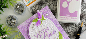 Blooming Wreath embossing folder card idea featuring white heat embossed background, arched design, and layered purple dragonflies from the Dragonfly Duo by Simon Says Stamp