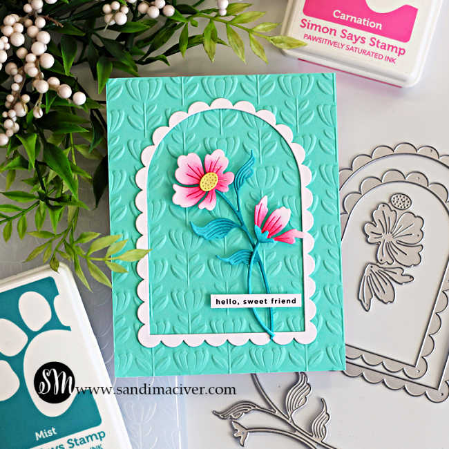 Elegant floral arch card with pink die cut flowers on an aqua embossed background using a scalloped frame, shown with coordinating Simon Says Stamp dies and inks