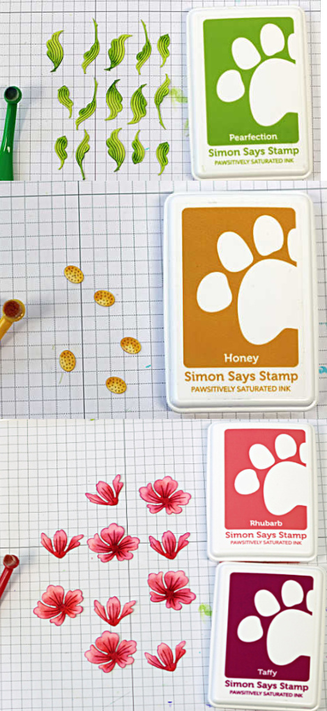 Die cut cardmaking elements ink blended with Simon Says Stamp inks, including green leaves, yellow flower centers, and pink floral pieces arranged on a grid mat.