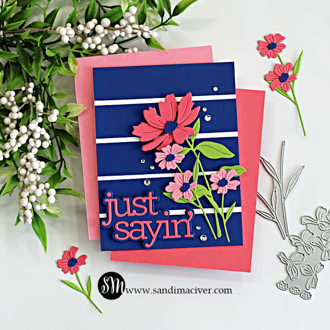 Bold cardmaking color combo with navy background featuring pink die cut flowers, green stems, white stripe accents, and a large “just sayin’” sentiment arranged in a diagonal card layout for a dramatic floral design.
