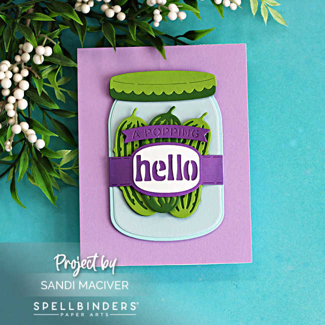 Die cut mason jar card with layered green pickles and purple “hello” sentiment, created with Spellbinders Market Jar Trio on a soft purple card base