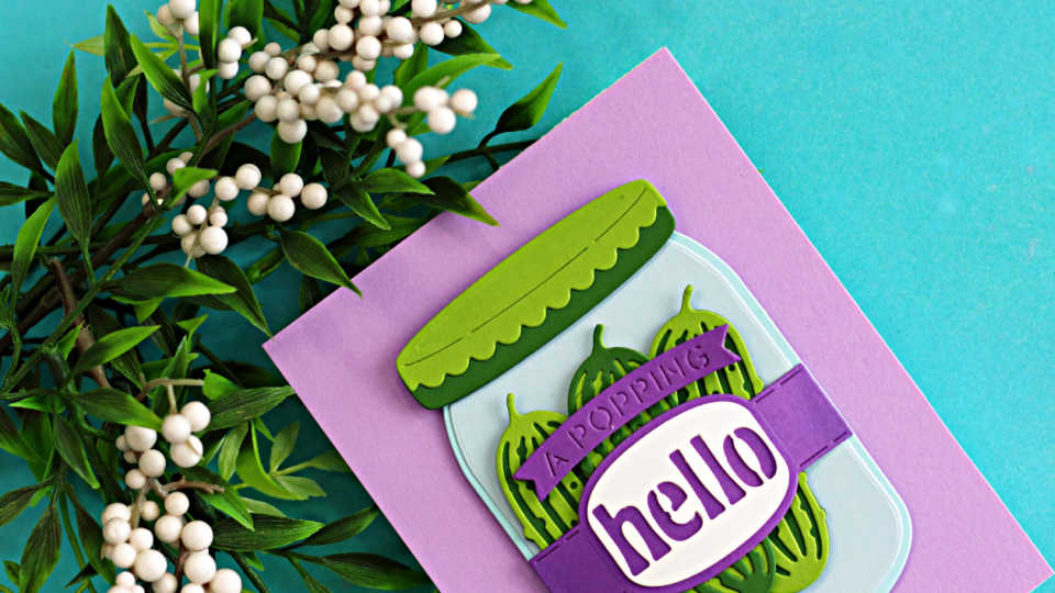 Die cut mason jar card featuring Spellbinders Market Jar Trio with layered green pickles, purple sentiment band, and “hello” greeting on a soft purple card base